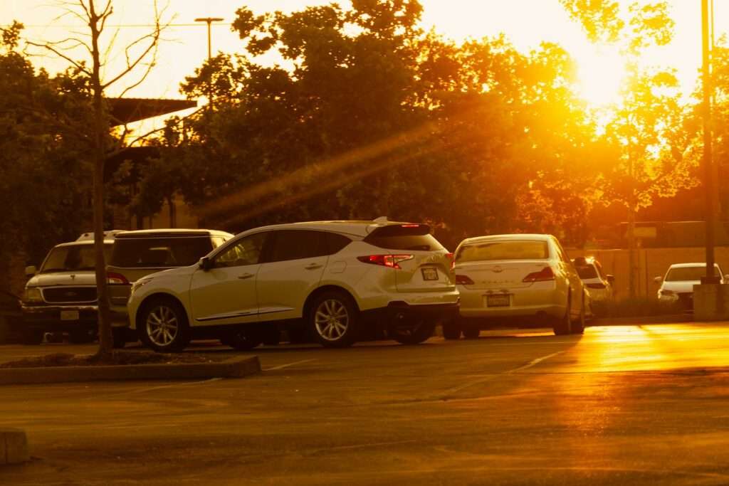 Cars parked outside with the warm setting sun.